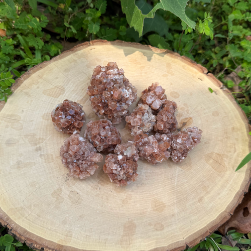 Crystal clusters on a wooden stump with a natural green background