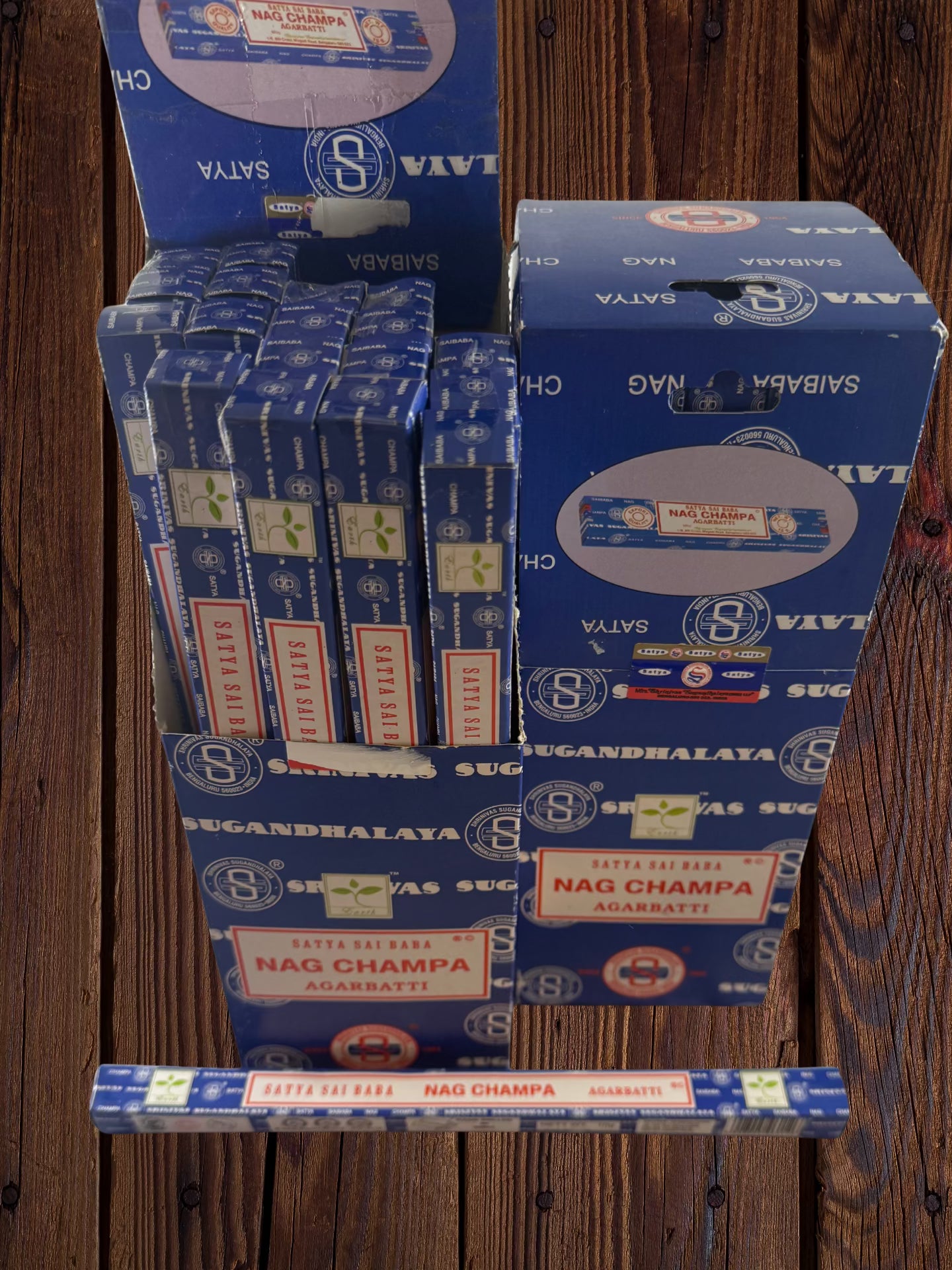 Open display box of Satya Sai Baba Nag Champa 10g incense beside a closed box and single package⠋