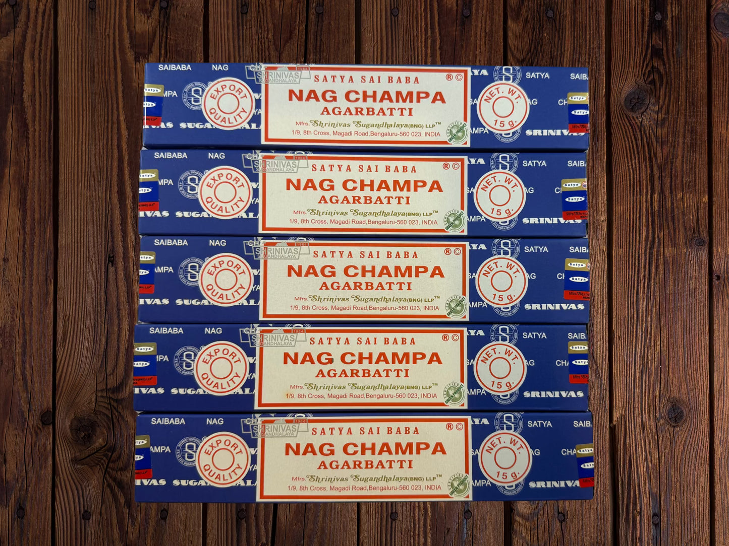 Five blue Satya Sai Baba Nag Champa incense packages on a white brick background