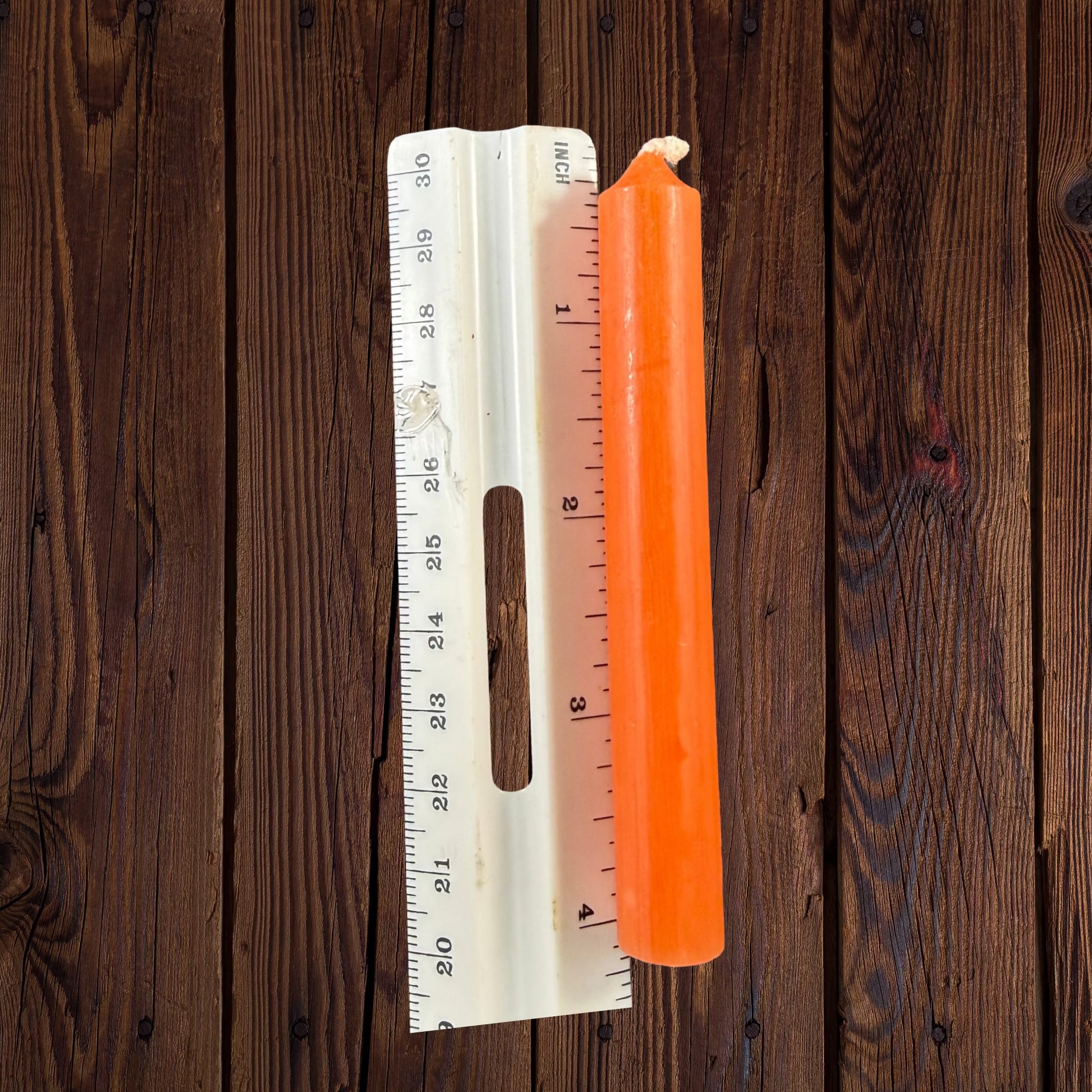 Candle beside ruler: Orange chime candle beside an inch ruler showing its approximately 4-inch length