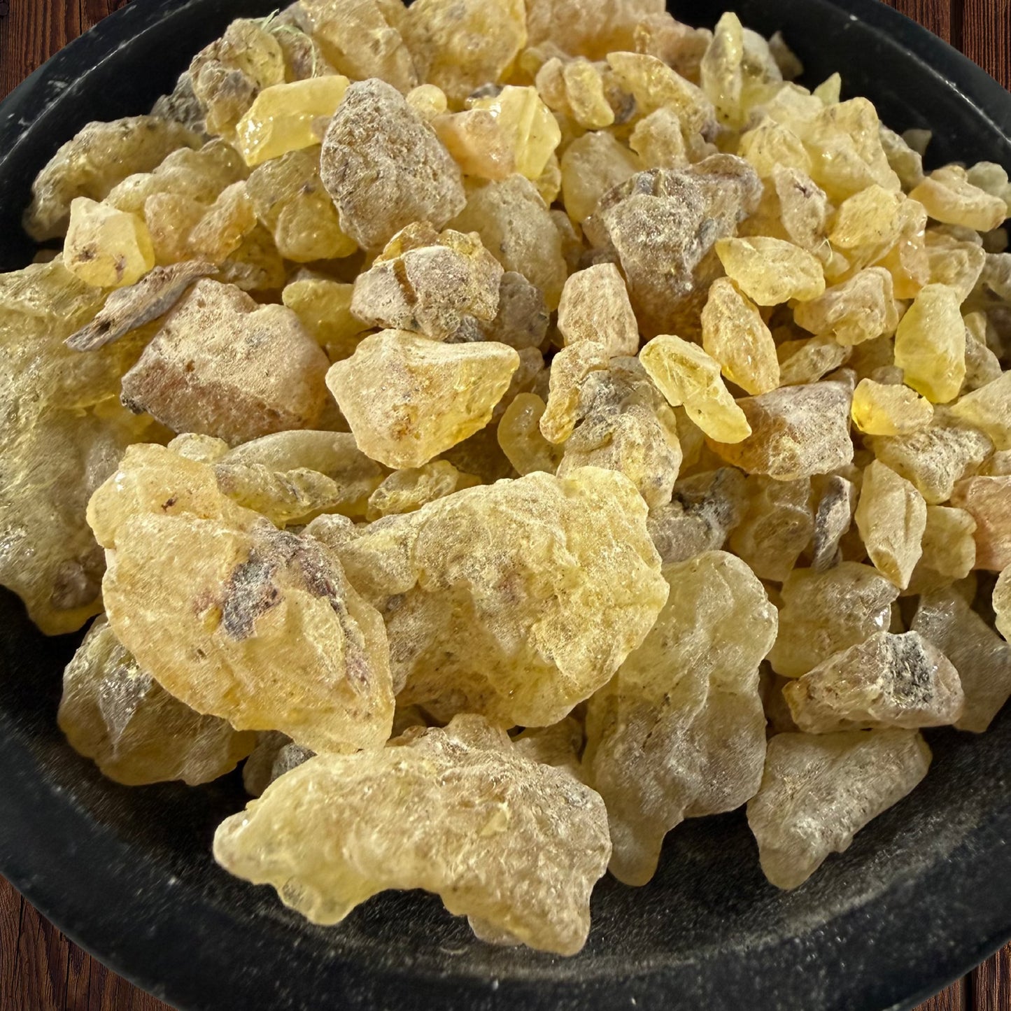 close up of Peruvian golden copal resin pieces in a black bowl 