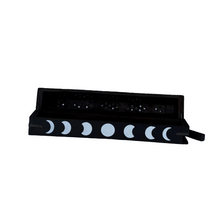 Black incense holder with moon phase design on a white background