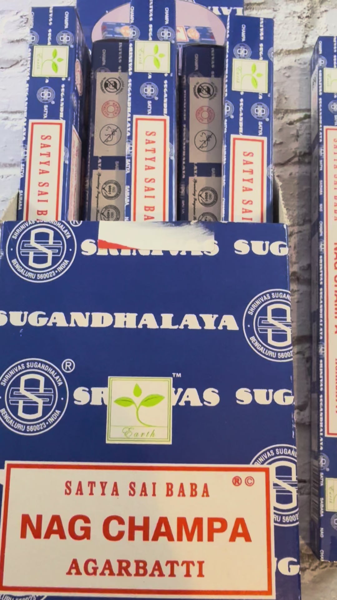 Open display box of Satya Sai Baba Nag Champa 10g incense beside a closed box and single package⠋